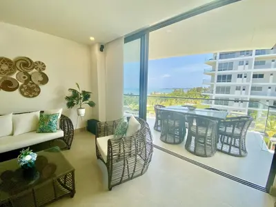 a living room with a balcony with a table and chairs at Apartamento de Lujo Morros Zóe - Manzanillo - Cartagena in Cartagena de Indias