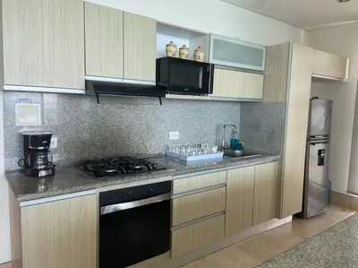 a kitchen with a stove and a refrigerator at Las 4 Estaciones Alojamientos de Ensueño Coveñas in Coveñitas