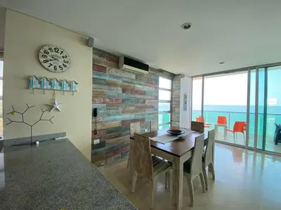 a dining room with a table and a clock on a wall at Las 4 Estaciones Alojamientos de Ensueño Coveñas in Coveñitas