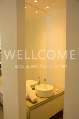a bathroom with a sink and a mirror with a welcome sign at Loft Distrito 90 in Barranquilla