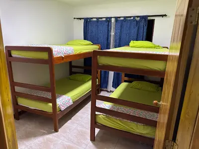 a room with three bunk beds and a window at Cabaña #5 en Condominio Mar de Coveñas in Coveñas