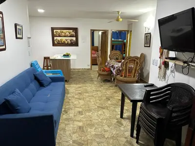 a living room with a blue couch and a tv at Cabaña #5 en Condominio Mar de Coveñas in Coveñas