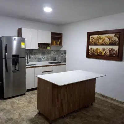a kitchen with a refrigerator and a table in it at Cabaña #5 en Condominio Mar de Coveñas in Coveñas