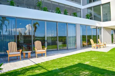 a house with glass windows and chairs on a patio at Apartamento vista al Mar lateral Panoramic View,Spectacular building,Pools, Beach Morros zoe ultimo piso in Cartagena de Indias