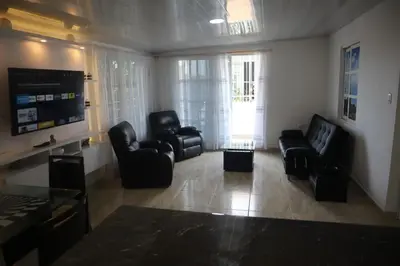a living room with black chairs and a tv at Penthouses La Fe in Cartagena de Indias