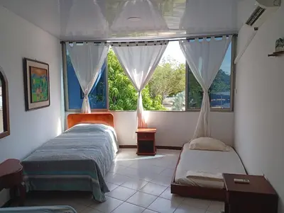 two beds in a room with a window at Condominio, Cabaña 202 in Puerto Viejo
