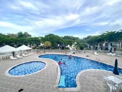 a swimming pool with chairs and people in it at Condominio, Cabaña 202 in Puerto Viejo
