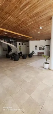 a large empty room with a wooden ceiling and plants at Condominio, Cabaña 202 in Puerto Viejo