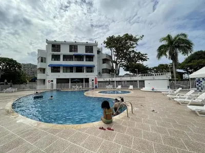 a group of children sitting in a swimming pool in front of a building at Condominio, Cabaña 202 in Puerto Viejo