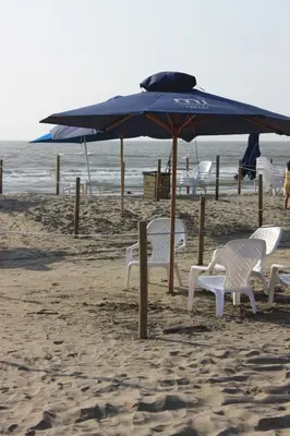 a group of chairs and an umbrella on the beach at Apartaestudio acceso al mar in Cartagena de Indias