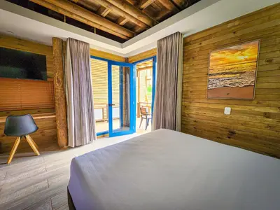 a bedroom with a bed in a room with wooden walls at Hotel Explore Caño Dulce in Tubará