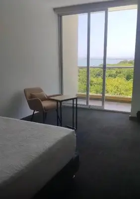 a bedroom with a bed and a chair and a window at Hotel Explore Caño Dulce in Tubará