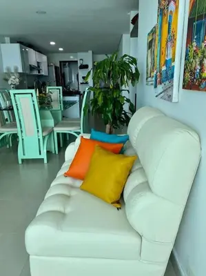 a white couch with colorful pillows in a room at Apartamento torres del lago 1102 in Cartagena de Indias