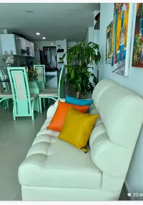 a white couch with colorful pillows on it in a room at Apartamento torres del lago 1102 in Cartagena de Indias