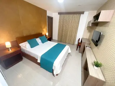 a hotel room with a bed and a television at Hotel Prado 72 INN in Barranquilla
