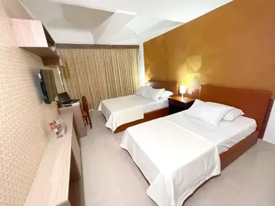 a hotel room with two beds and a television at Hotel Prado 72 INN in Barranquilla