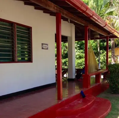 a porch of a house with a hammock on it at Cabaña Coveñas Los García in Coveñas
