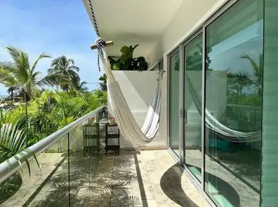 a hammock on the balcony of a house at Beachfront Bliss-2BR Haven Steps from Sandy Shores in Cartagena de Indias