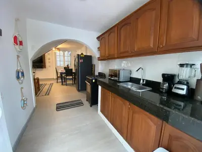a kitchen with wooden cabinets and a black counter top at Cozy apt. on Manga Bay Blvd. (Apto. Bahia manga) in Cartagena de Indias