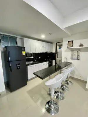 a kitchen with a black refrigerator and some bar stools at TU VISTA IDEAL in Cartagena de Indias