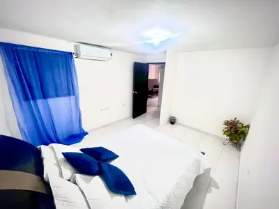 a bedroom with a bed with blue pillows at Apartamento encanto in Cartagena de Indias
