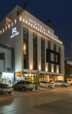 a hotel building with cars parked in front of it at Hotel Rilux Cartagena in Cartagena de Indias