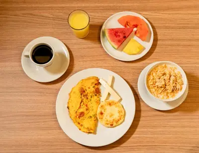 a table with two plates of breakfast foods and a cup of coffee at Hotel Rilux Cartagena in Cartagena de Indias