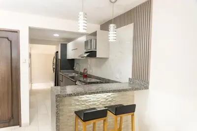 a kitchen with a counter and stools in a room at Apartamento en Cartagena cerca al aeropuerto y Playa in Cartagena de Indias