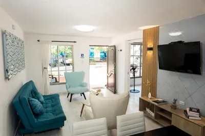 a living room with a couch and chairs and a television at Apartamento en Cartagena cerca al aeropuerto y Playa in Cartagena de Indias