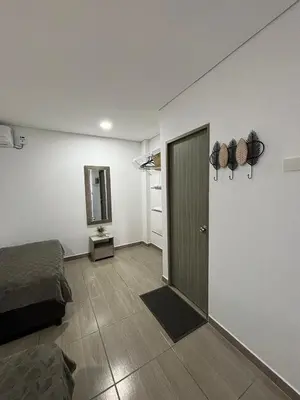 a room with a bed and a door and a mirror at Cabaña Milagro Bonito in Santa Marta