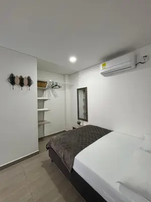 a white bedroom with a bed and a closet at Cabaña Milagro Bonito in Santa Marta