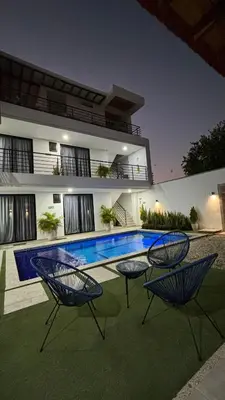 a house with two chairs and a swimming pool at Cabaña Milagro Bonito in Santa Marta