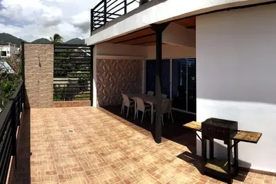 a balcony of a house with a table and chairs at COZY, Apartamento a solo 10 minutos Caminando a Playa Dormida, con Piscina y Parqueadero. in Santa Marta
