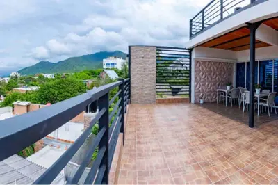 a balcony of a house with a table and chairs at COZY, Apartamento a solo 10 minutos Caminando a Playa Dormida, con Piscina y Parqueadero. in Santa Marta