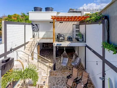 a balcony with chairs and stairs on a house at COZY, Apartamento a solo 10 minutos Caminando a Playa Dormida, con Piscina y Parqueadero. in Santa Marta