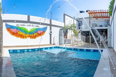 a pool with a water fountain in front of a building at COZY, Apartamento a solo 10 minutos Caminando a Playa Dormida, con Piscina y Parqueadero. in Santa Marta