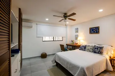 a bedroom with a bed and a ceiling fan at Apartamento con salida a la playa in Santa Marta