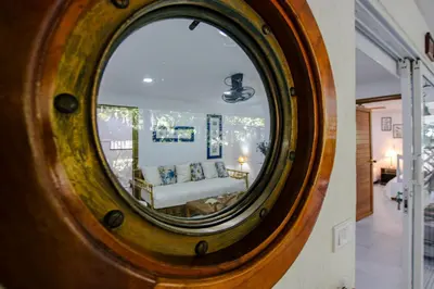 a mirror reflecting a couch in a living room at Apartamento con salida a la playa in Santa Marta