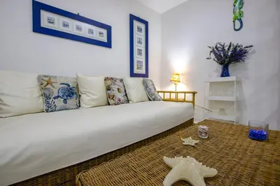 a living room with a white couch and a table at Apartamento con salida a la playa in Santa Marta