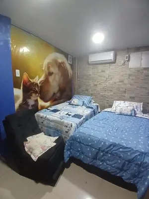 a room with two beds and a painting of a dog and a cat at casa castillo san felipe in Cartagena de Indias