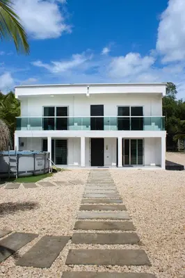 a white house with a pathway in front of it at Cabaña los Abuelos in Coveñas