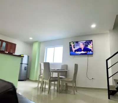 a dining room with a table and a tv on the wall at Apartamento 405 in Cartagena de Indias