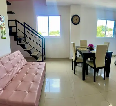 a living room with a table and a pink couch at Apartamento 408 in Cartagena de Indias