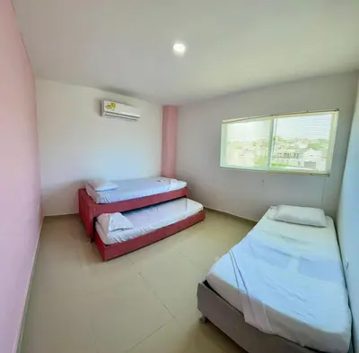 a small room with two beds and a window at Apartamento 408 in Cartagena de Indias
