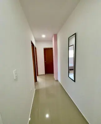 a hallway with white walls and a mirror on the wall at Apartamento 408 in Cartagena de Indias