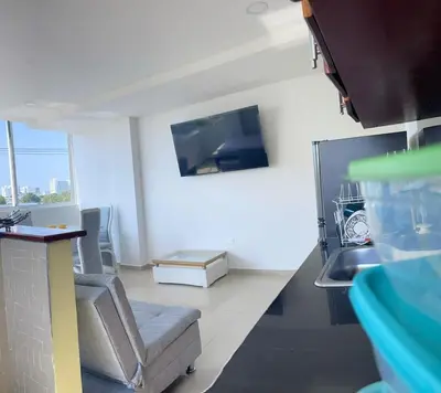 a living room with a couch and a tv on the wall at Apartamento 301 in Cartagena de Indias