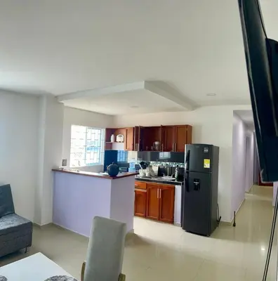 a kitchen with a black refrigerator and wooden cabinets at Apartamento 204 in Cartagena de Indias
