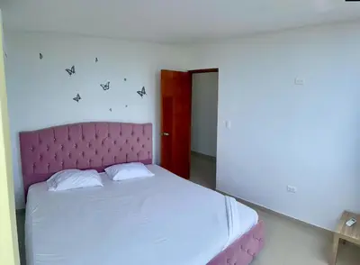 a bed with a pink headboard in a room at Apartamento 401 in Cartagena de Indias