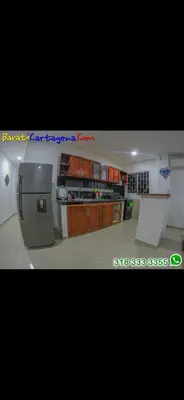 a kitchen with wooden cabinets and a refrigerator at Apartamento 303 in Cartagena de Indias