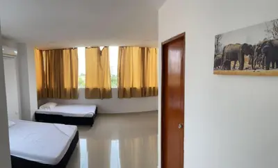 a room with two beds and a window with elephants at Apartamento 402 in Cartagena de Indias